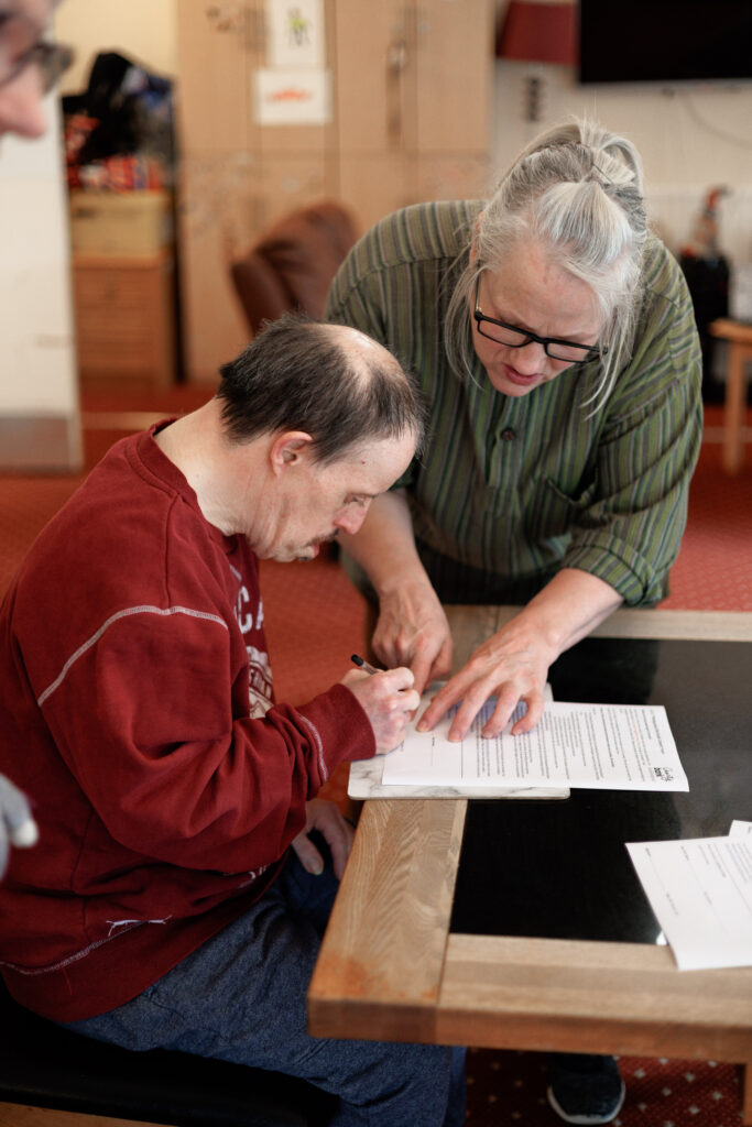 Birmingham Supported Living carer helping person to write