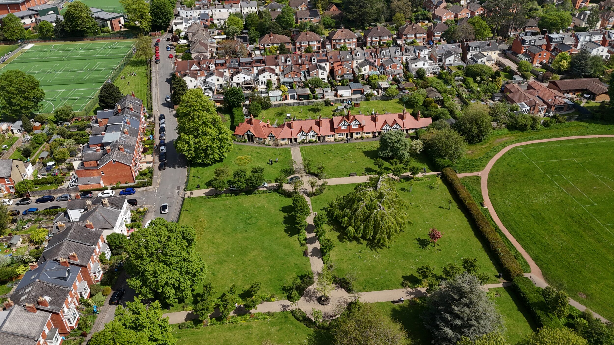 Wide drone shot of Hays Cottages in Cheltenham with surrounding houses and park