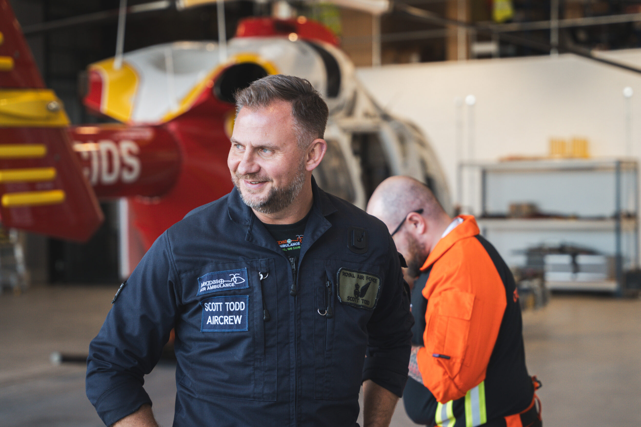 Air Ambulance Air Crew laughing in front of helicopter in hangar at MAGPAS headquarters